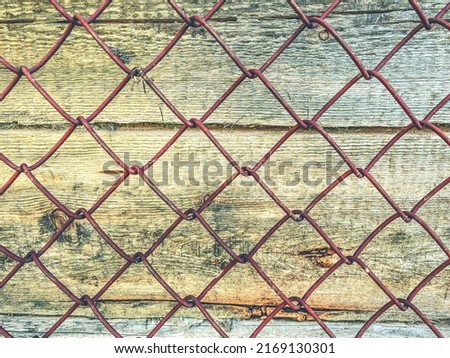 texture, background. natural, processed wood. the texture of the logs, the trees are behind a metal mesh. farm fence.