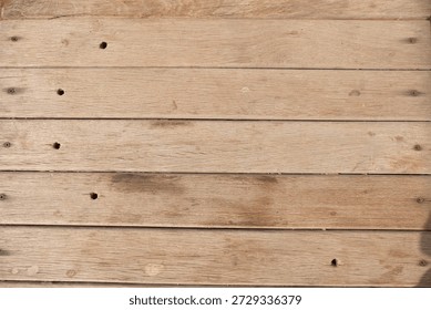 Texture background of old light brown wooden planks with nail holes.