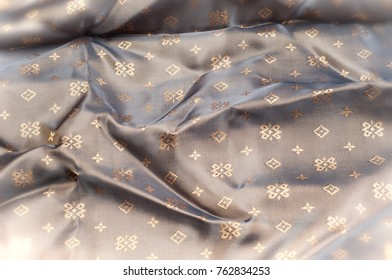 Texture background pattern. Brown silk fabric. Abstract background of luxury fabrics or liquid waves or wavy creases. Smooth elegant golden silk or satin In Sepia toned. Retro style