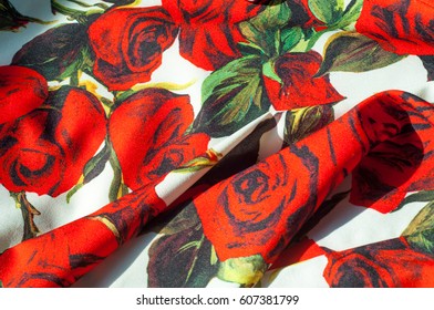 Texture, background, pattern. Cloth Silk Abstract Pattern. On the fabric are painted roses. Red roses on a white background