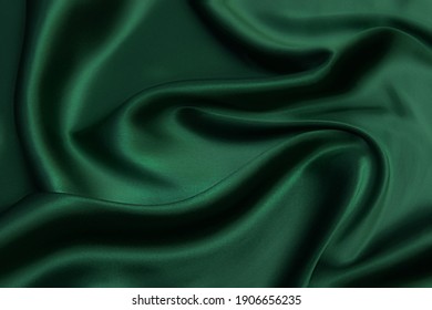 Texture, background, pattern. Texture of green silk fabric. Beautiful emerald green soft silk fabric. - Shutterstock ID 1906656235