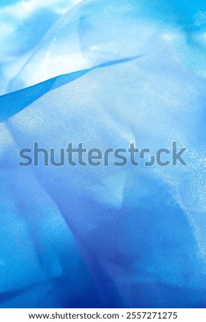 Texture, background, pattern. Silk fabric in azure blue as background. abstract folds.
Smooth elegant blue silk or satin texture. colors