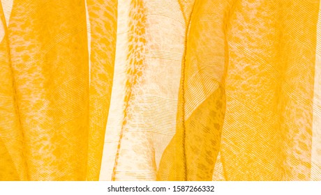 The texture, background, pattern, white yellow silk fabric is textile. Its properties differ from the woven material in that it is more flexible and easier to design.