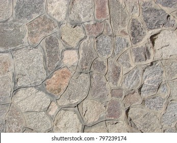texture, background. The pavement of granite stone. Paved roadway street. any paved area or surface. Old cobblestone road pavement texture, grass between stones