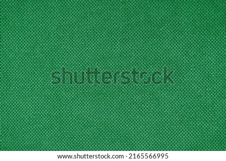 Texture background of velours green fabric. Fabric texture of upholstery furniture textile material, design interior, wall decor. Fabric texture close up, backdrop, wallpaper.