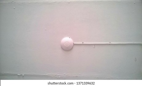 Texture, background, wallpaper, image of a white alarm system installed on an old whitewashed ceiling in any public building.
