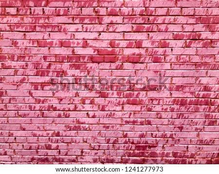 Texture of a beautiful unique unusual pink tender old cracked brick wall of rectangular bricks with seams painted with pink old shabby paint. The background.