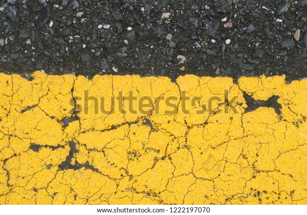 Texture of black asphalt road
with yellow line background, pattern of old cracked yellow painted
on asphalt surface can use for background and wallpaper, close
up
