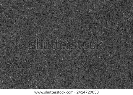 Texture of the black synthetic material of the kitchen hard urethane abrasive cleaning sponge, top view close-up
