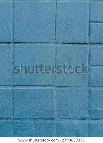 The texture of the brick wall is rather soft but not rough and is light blue in color.
