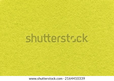 Texture of bright green and yellow colors paper background, macro. Structure of dense lime craft cardboard. Felt backdrop closeup.