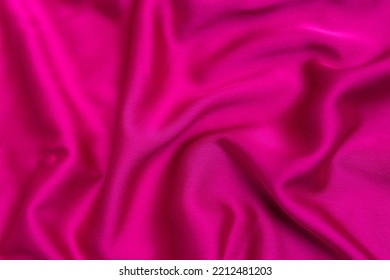 Textura de seda de tejido rosa brillante o satén  Fussia de tela o color de color crimson  Antecedentes abstractos 