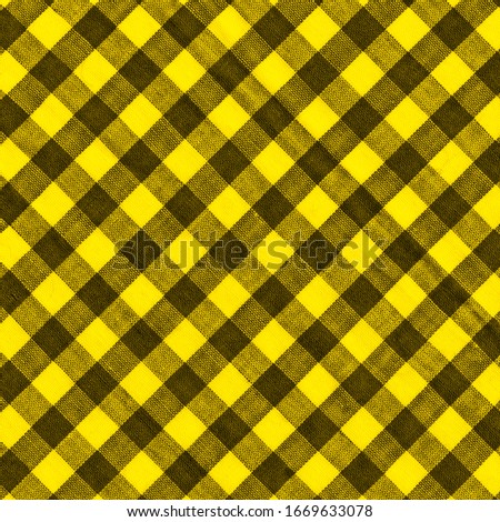 The texture of the bright yellow of binding gingham fabric. Yellow textile background. Fabric plaid. Close-up