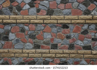 texture colored stones   cobblestones and brown bricks in the fence wall