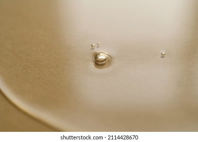 The Texture Of Cosmetic Oil On A Golden Background.