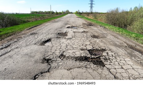 The texture of cracked old asphalt in need of repair. The road is full of holes and potholes.                    