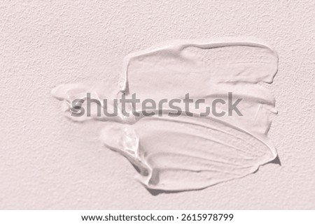 The texture of the cream on a light background. Translucent serum is smeared on the backdrop. The consistency of glycerin gel. Cosmetic smear. Beauty products