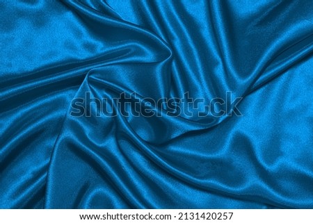 Texture of crumpled blue satin fabric, beautiful pattern, top view.
