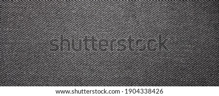 The texture of dark gray fabric is fluted in stripes.Background of dense gray fabric.