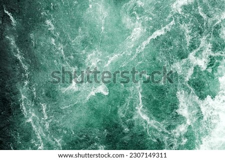 Texture of dark stormy water surface with white waves and splashes. Abstract nature backgrounds