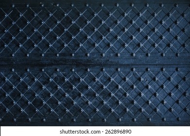 Texture of dark wooden gate with metal strips chipped.