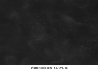 The texture of dirty scratched plastic.  Abstract rectangular dark background with light blur.