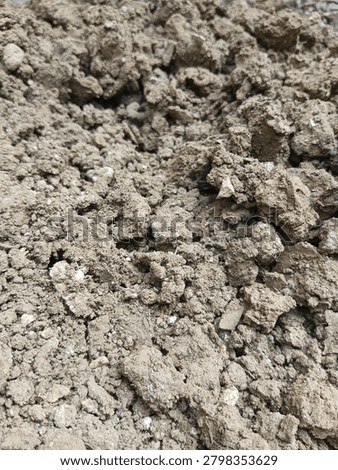 Texture of dry brown soil with rough clods and earth chunks, natural ground surface background