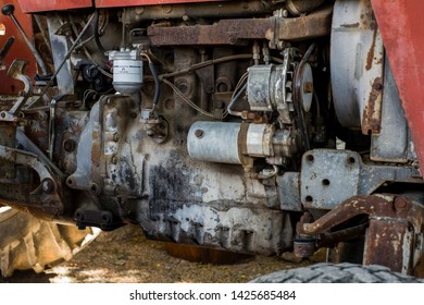 texture of the engine of an old red tractor in the field