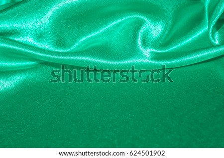 Texture, fabric, background. Abstract background of luxurious fabric or liquid waves or wavy grunge crease silk satin texture of velvet material or luxurious Christmas . green