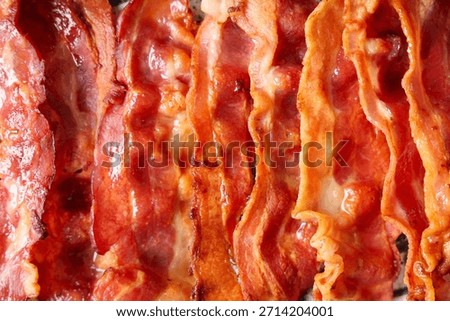 Texture of fried bacon rashers as background, closeup