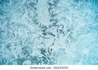 The texture is frozen glass, the background of the frost pattern is blue. Snowflakes on the glass - Shutterstock ID 2101376767