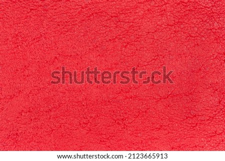 Texture of genuine leather, fragment of the leather product dyed in red  close-up, background 
