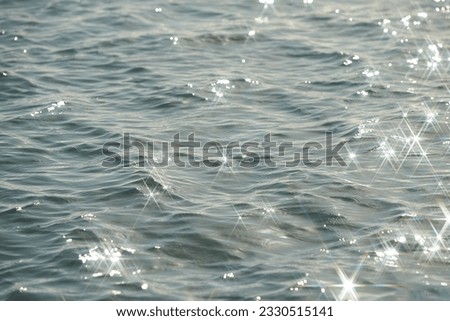 Texture of glitter water and soft waves. sparkling in water - background. sea water with sun glare and ripple. Powerful and peaceful nature concept.