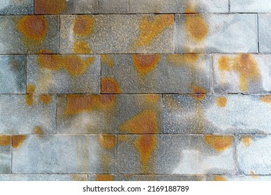 Texture. Granite Block Wall With Water Streaks And Orange Spots.