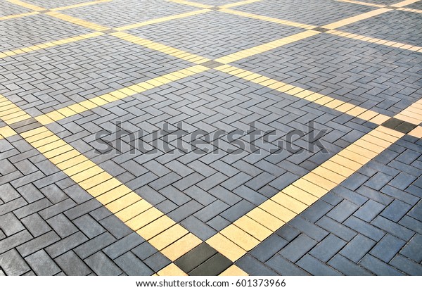 通りの地面に グレーと黄色のパターンの舗装タイルのテクスチャー パースビュー 石の床の背景にセメントレンガ コンクリート舗装用スラブ敷石 歩道の舗装パターン の写真素材 今すぐ編集