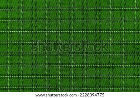 The texture of the green fabric in a large cell. Textile. fibers. checkered fabric