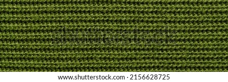 Texture of green knitted fabric as background. Banner for design