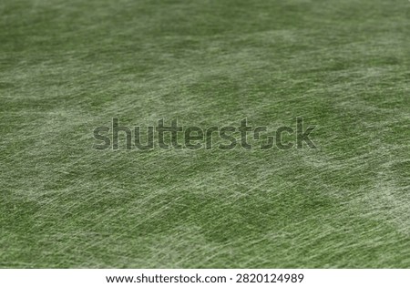 Texture of green non-wooven material for background. Selective focus. 