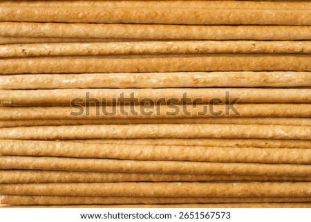Texture of horizontal breadsticks. Thin long biscuits, straws.