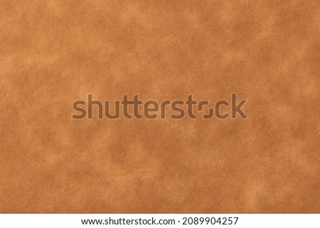 Texture of light brown old paper, crumpled background. Vintage beige grunge surface backdrop. Structure of craft parchment cardboard. Velvet matt texture of nubuck textile.
