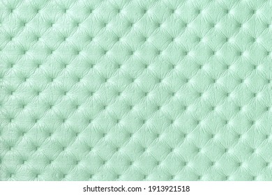 Texture of light green leather background with capitone pattern, macro. Cyan textile of retro Chesterfield style. Vintage mint fabric backdrop.