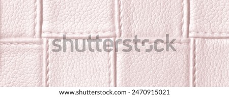 Texture of light pink leather background with square pattern and stitch, macro. Abstract rose backdrop from modern decorative light pearl textile with geometric shape.