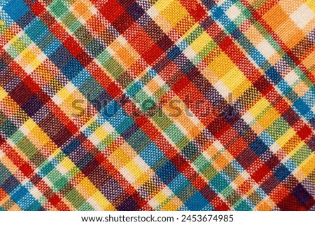 The texture of linen fabric in a large cage of blue, red, yellow and white. Scottish tailoring material. Checkered fabric
