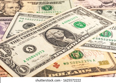 Texture of multiple US dollar banknotes. Background from paper money. A few dollars of varying nominal values. USA dollar bills. Close-up of multiple American dollar greenbacks.