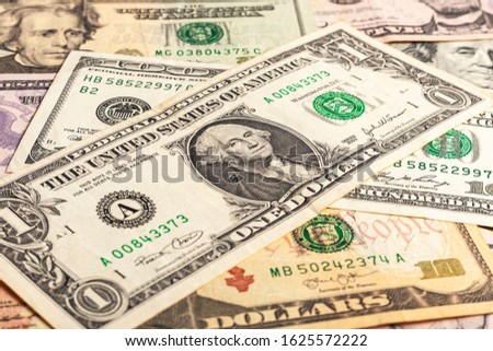 Texture of multiple US dollar banknotes. Background from paper money. A few dollars of varying nominal values. USA dollar bills. Close-up of multiple American dollar greenbacks.