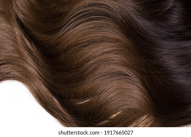 A Texture Of Natural Looking Synthetic Dark Brown And Walnut Wavy Curly Hair, Cold Wave Style, Isolated On White 