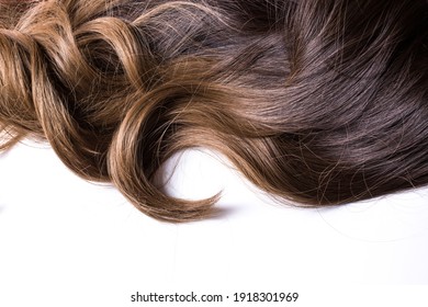 A Texture Of Natural Looking Synthetic Dark Brown Shiny Wavy Curly Hair With Highlights Isolated On The White Background