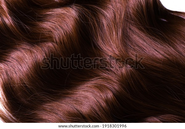 A texture of\
natural looking synthetic dark copper walnut wavy curly hair, cold\
wave style, on white\
background