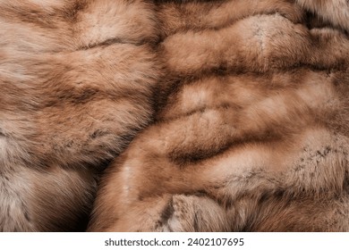 Texture of natural marten fur, luxury outerwear for women, soft fluffy surface of women's winter fur coat close-up for banners and posters.