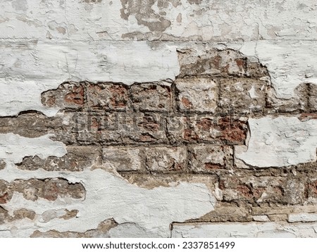 Texture of old brick wall with collapsed plaster. Background of shabby building surface. Destroyed stone wall with fallen plaster. Weathered surface. Copy space. Selective focus.